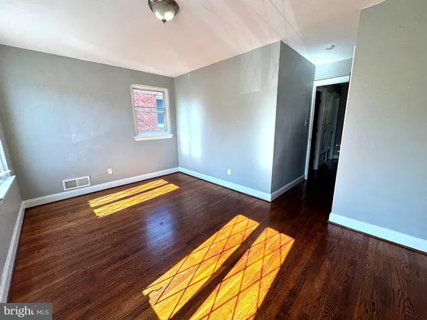 a view of an empty room with wooden floor
