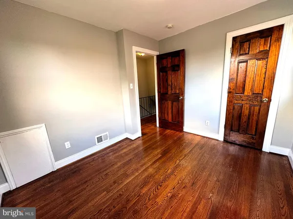 an empty room with wooden floor and closet