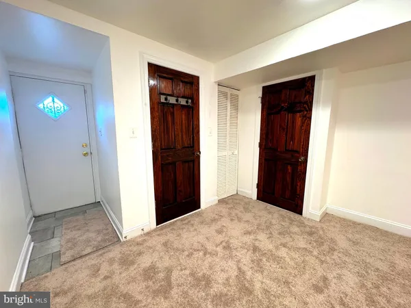 a view of an empty room with closet and a window