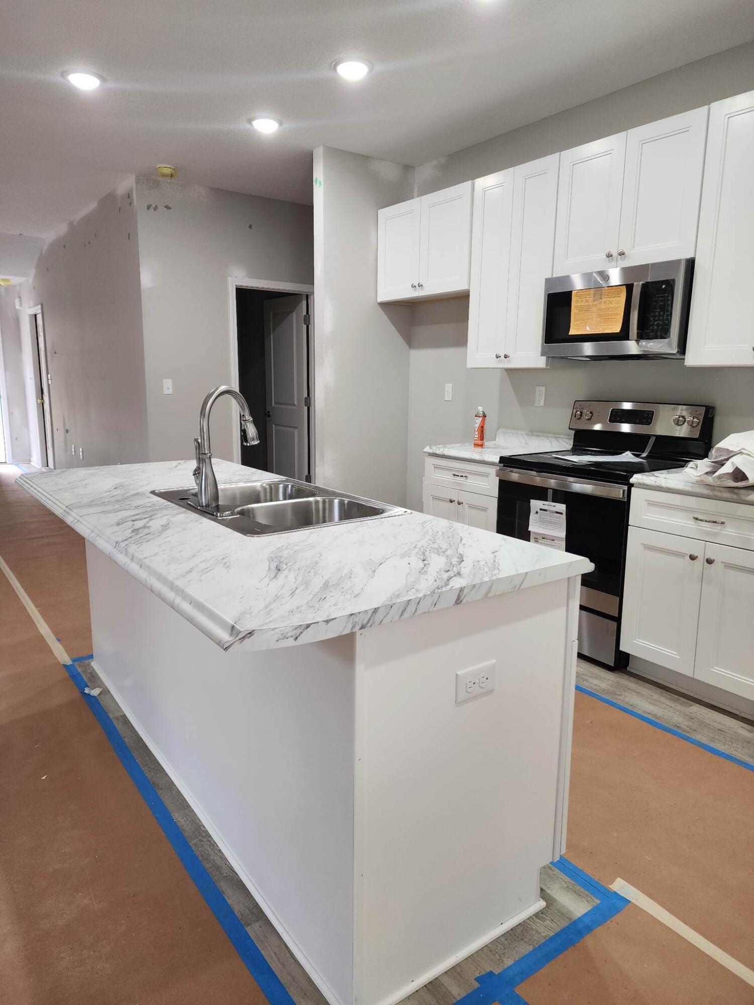 1249 Martin Road DeFuniak Springs, FL 32433 - Photo 2 of 15 a kitchen with kitchen island granite countertop a sink appliances cabinets and a counter top space