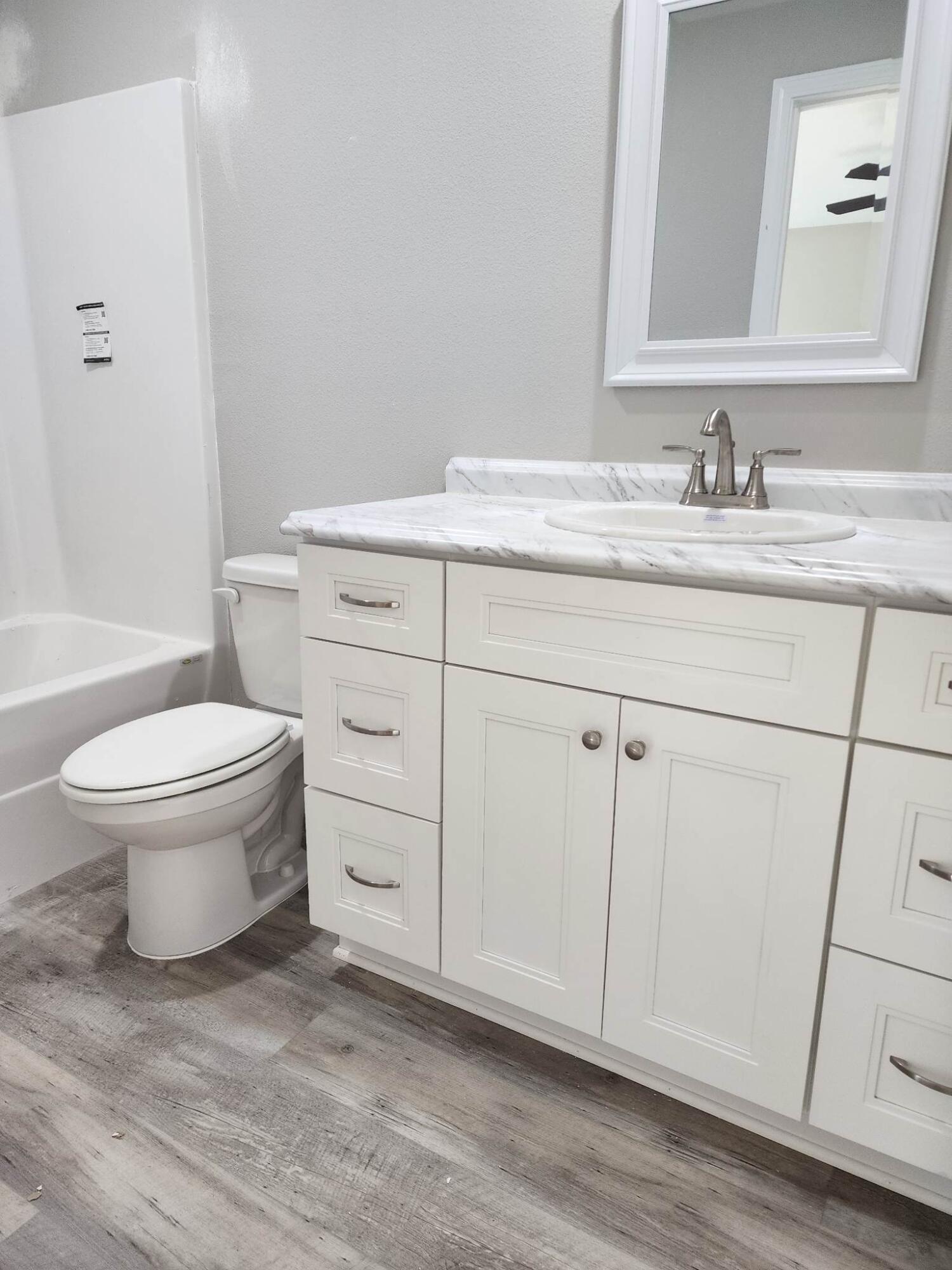 1249 Martin Road DeFuniak Springs, FL 32433 - Photo 7 of 15 a bathroom with a granite countertop toilet sink and mirror