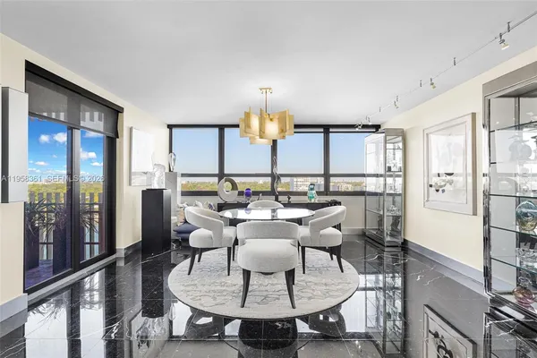 a dining room with furniture a chandelier and window