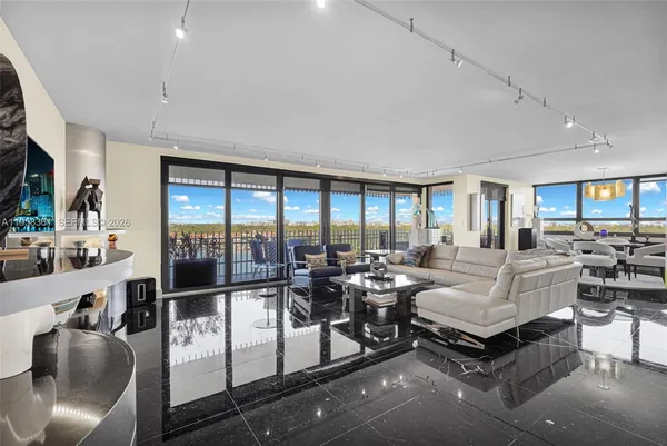 a large white room with a large window and furniture