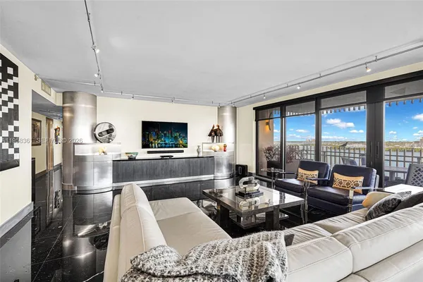 a living room with furniture a flat screen tv and a floor to ceiling window