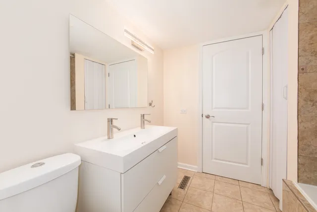 a bathroom with a sink a toilet and a mirror