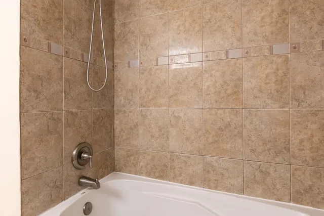 a bathroom with a bath tub with a shower