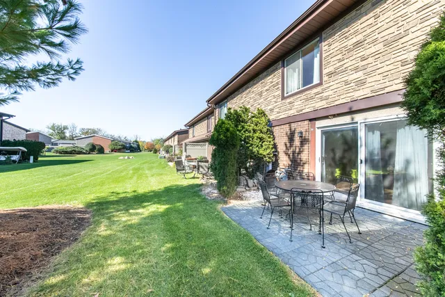 a view of a house with backyard sitting area and garden