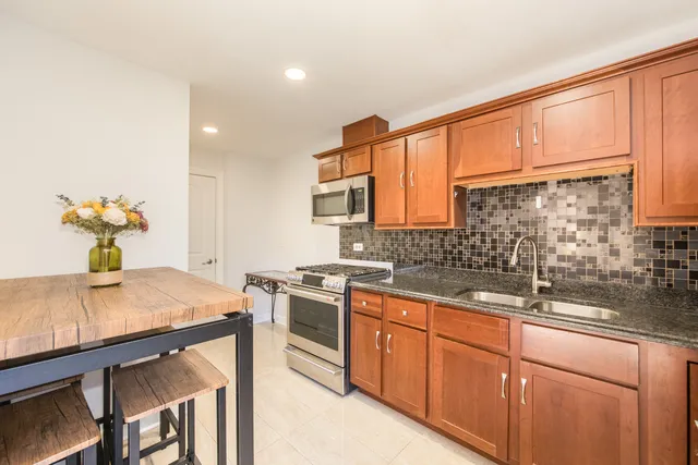 a kitchen with stainless steel appliances granite countertop a sink a stove and cabinets
