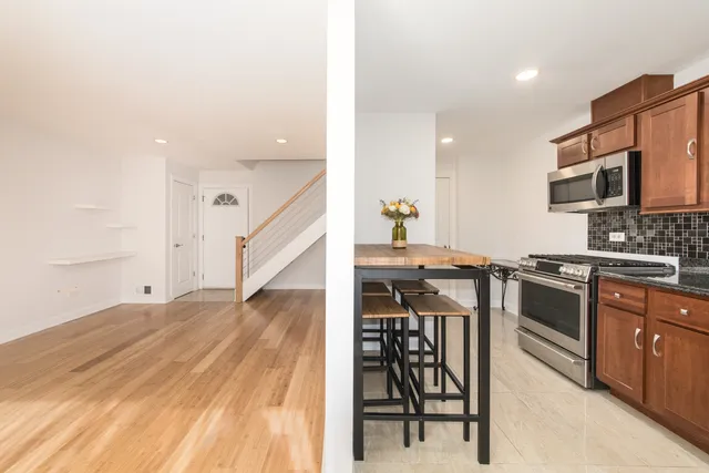 a kitchen with stainless steel appliances kitchen island granite countertop a stove a sink and a microwave