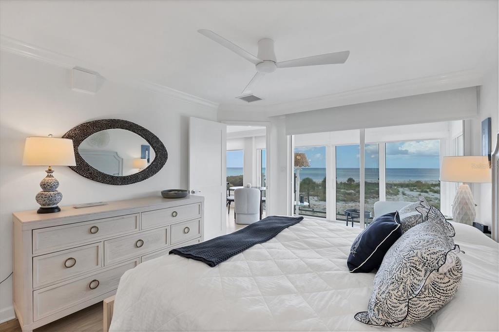 5000 Gasparilla Road, Unit 304 Boca Grande, FL 33921 - Photo 17 of 30 a bedroom with a bed a mirror on dresser and a large window