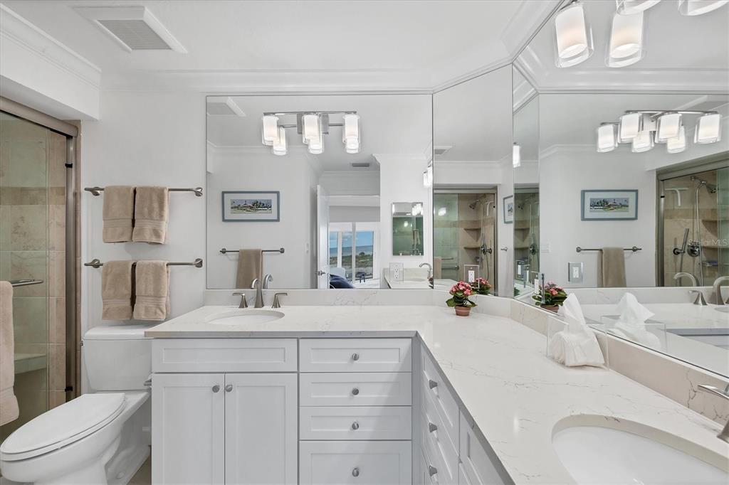 5000 Gasparilla Road, Unit 304 Boca Grande, FL 33921 - Photo 19 of 30 a bathroom with double vanity sink a mirror and a toilet