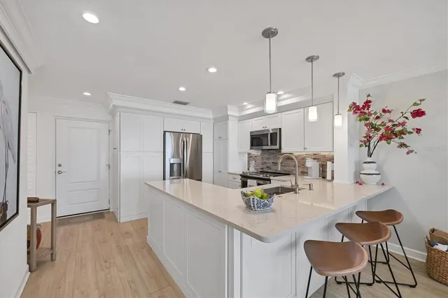 a kitchen with stainless steel appliances kitchen island granite countertop a refrigerator and microwave