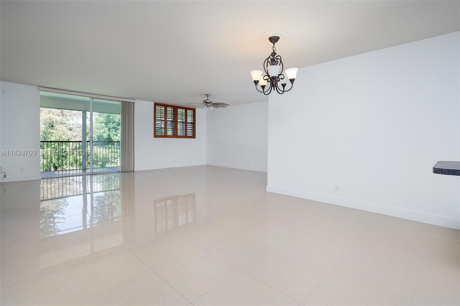 3150 West Rolling Hills Circle, Unit 307 Davie, FL 33328 - Photo 1 of 20 wooden floor in an empty room with a window
