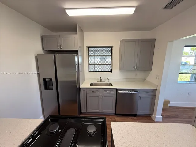 a kitchen with granite countertop a refrigerator and a stove
