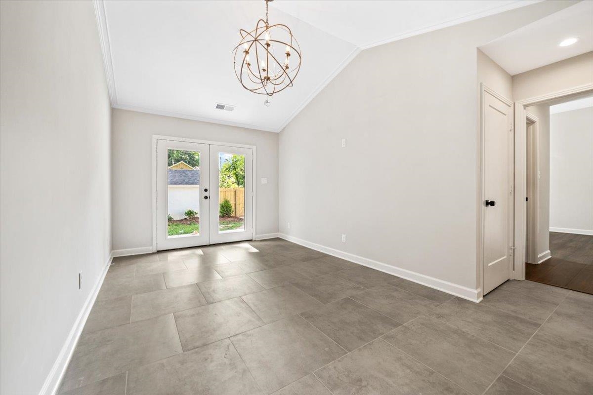 170 South Greer Street Memphis, TN 38111 - Photo 3 of 35 Vaulted ceiling with an orb chandelier, double glass-paneled doors, neutral wall paint, tile flooring, and a solid interior door
