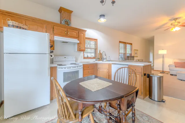 a kitchen with a table chairs a refrigerator and a stove