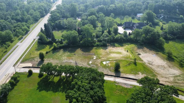 an aerial view of residential houses with outdoor space and trees