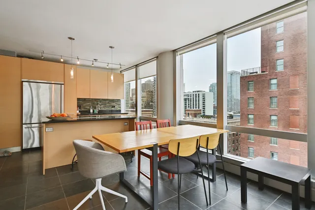 a kitchen with a table chairs refrigerator and cabinets