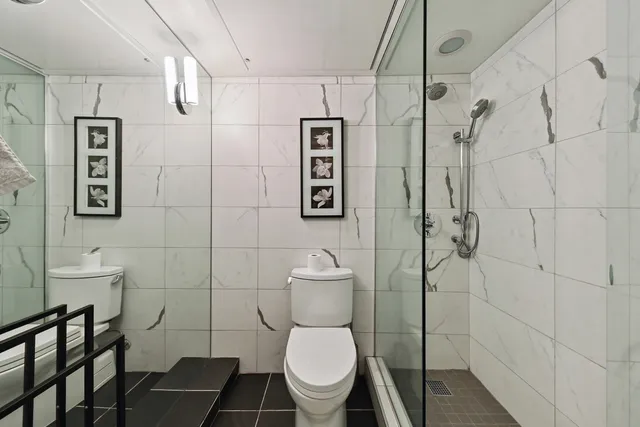 a white toilet sitting next to a bathroom sink