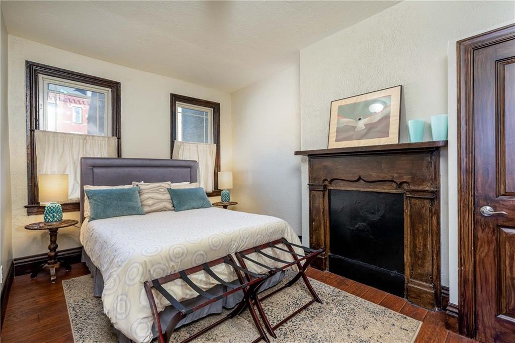 838 Spring Garden Avenue Pittsburgh, PA 15212 - Photo 17 of 24 a bedroom with a bed and a fireplace