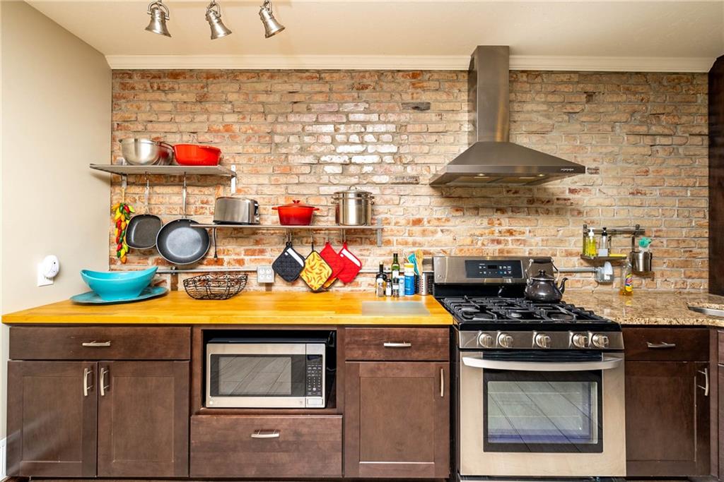 838 Spring Garden Avenue Pittsburgh, PA 15212 - Photo 7 of 24 a kitchen with stainless steel appliances granite countertop a stove and white cabinets