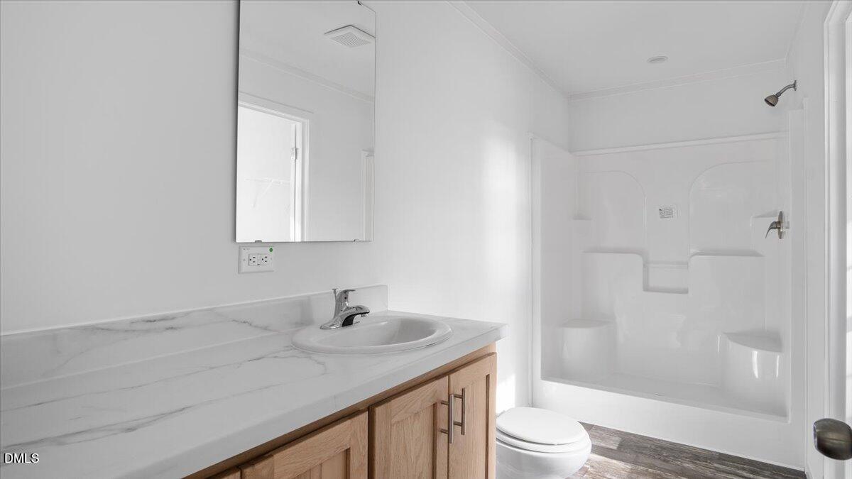 212 Ellington's Path Henderson, NC 27537 - Photo 24 of 36 a bathroom with a sink a toilet and shower