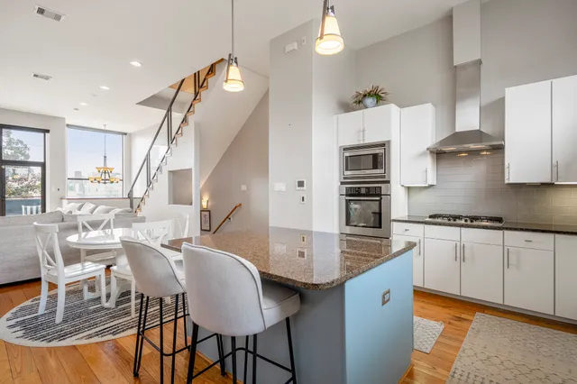 a kitchen with a table chairs refrigerator and microwave