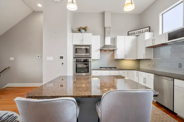a kitchen with kitchen island a sink table and chairs