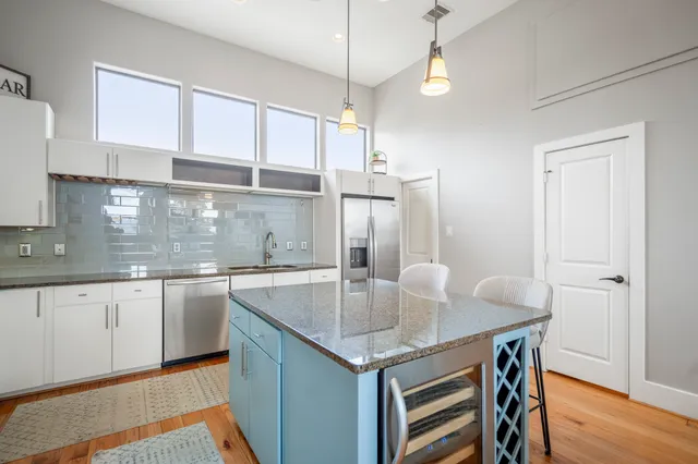 a kitchen with stainless steel appliances granite countertop a sink refrigerator and cabinets