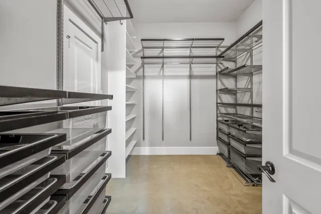 a spacious bedroom with a bed and a lamp