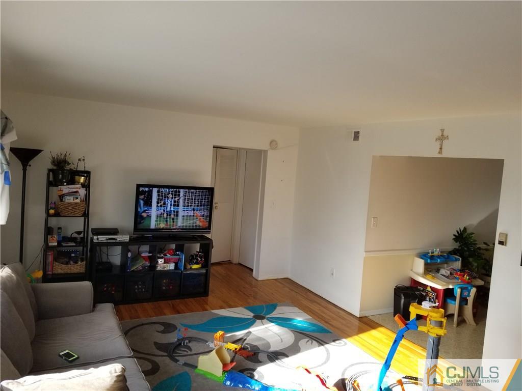 197 Evergreen Road, Unit 5B Edison, NJ 08837 - Photo 5 of 11 a bedroom with furniture and a flat screen tv