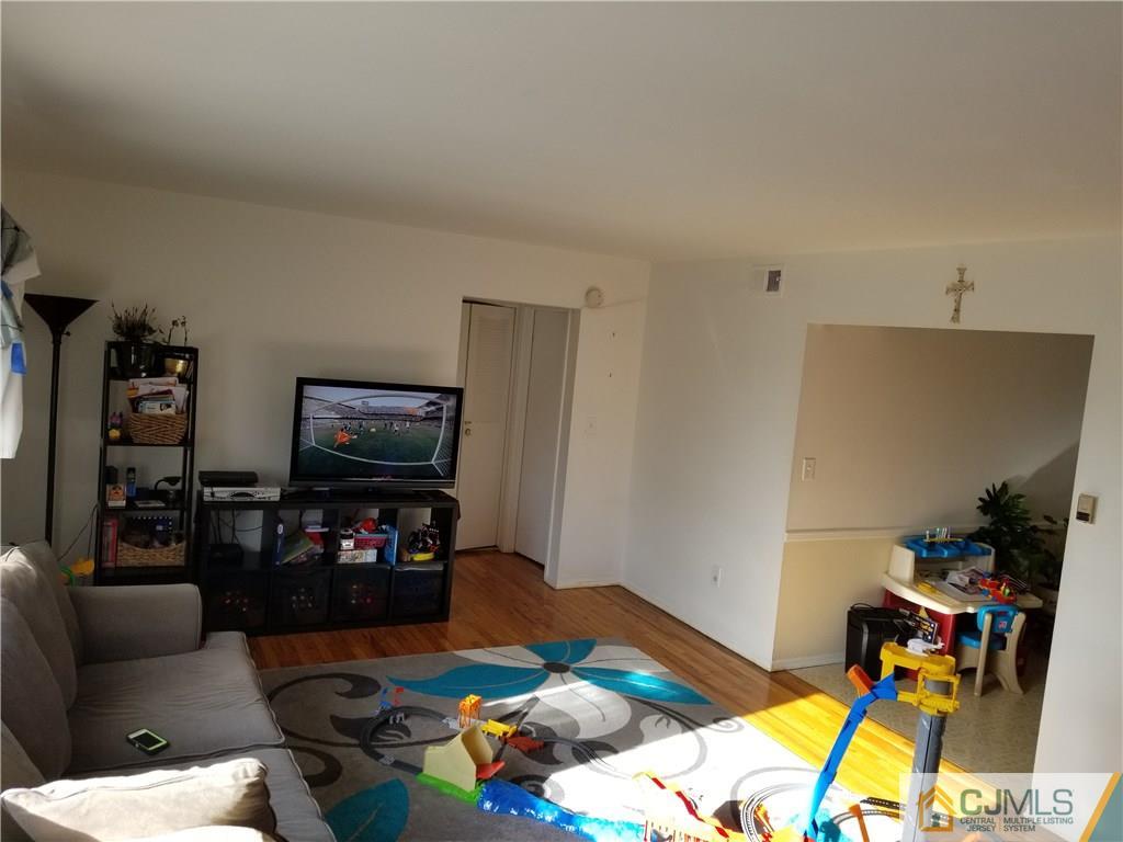 197 Evergreen Road, Unit 5B Edison, NJ 08837 - Photo 6 of 11 a bedroom with furniture and a flat screen tv