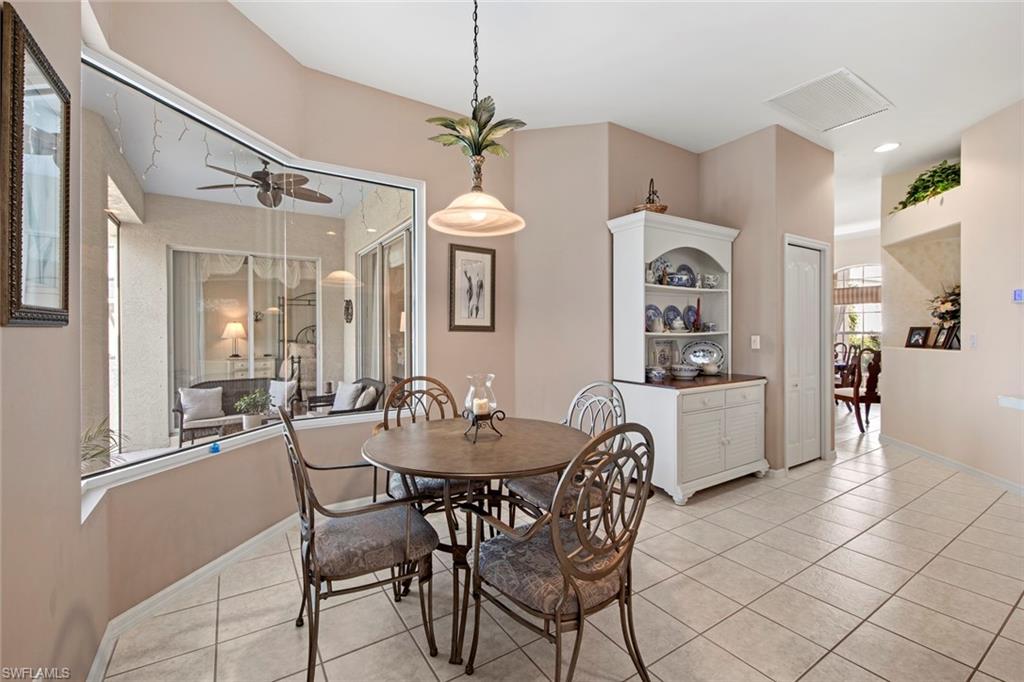 21516 Langholm Run Estero, FL 33928 - Photo 13 of 50 a view of a dining room with furniture and chandelier
