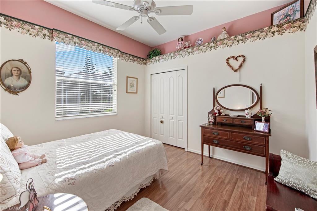 21516 Langholm Run Estero, FL 33928 - Photo 24 of 50 a bedroom with a bed and a chandelier