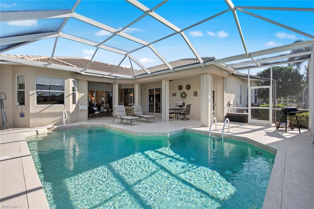 21516 Langholm Run Estero, FL 33928 - Photo 33 of 50 a view of a backyard with dining table and chairs with swimming pool