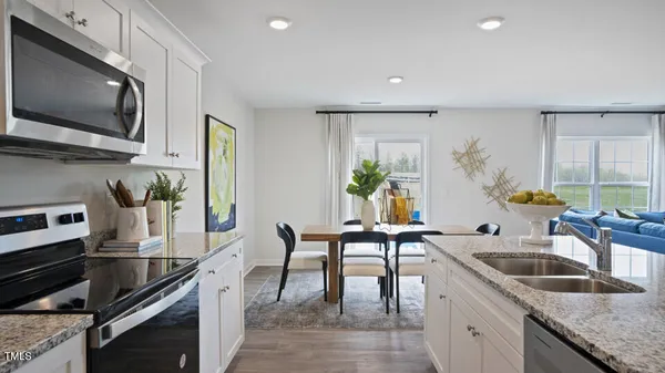 a kitchen with a dining table chairs and microwave
