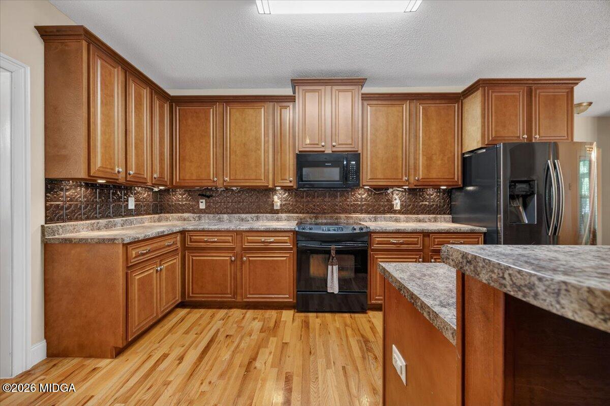 619 Grayridge Road Gray, GA 31032 - Photo 9 of 40 a kitchen with stainless steel appliances granite countertop a stove a sink dishwasher a refrigerator and cabinets with wooden floor
