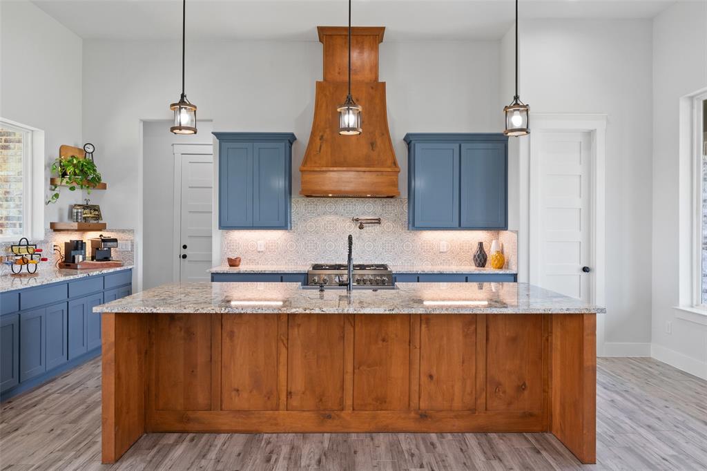 4411 Fm 751 Wills Point Wills Point, TX 75169 - Photo 20 of 40 a kitchen with kitchen island granite countertop wooden cabinets and wooden floor
