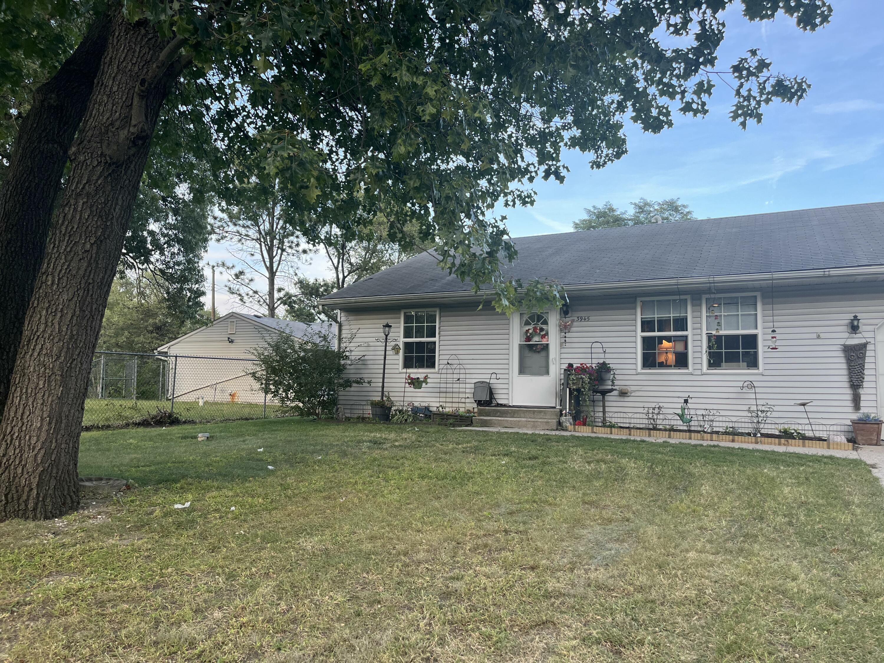 a front view of a house with a garden and trees