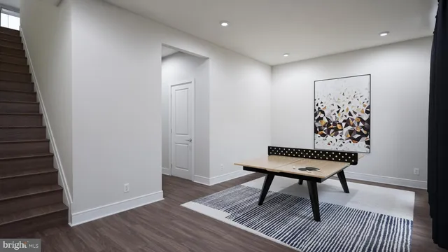 a view of a hallway with wooden floor and a bathroom