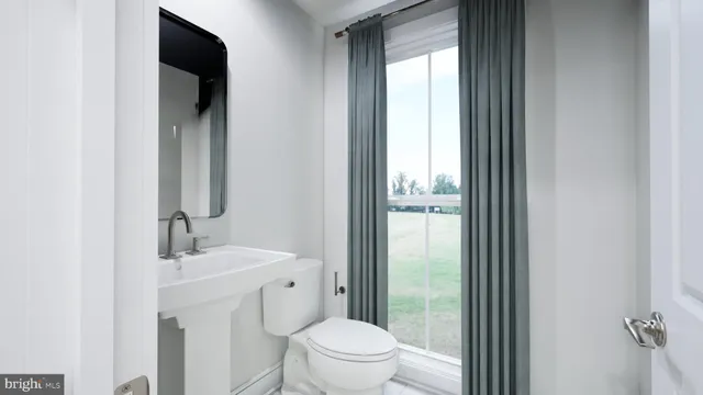 a bathroom with a toilet a sink and a mirror