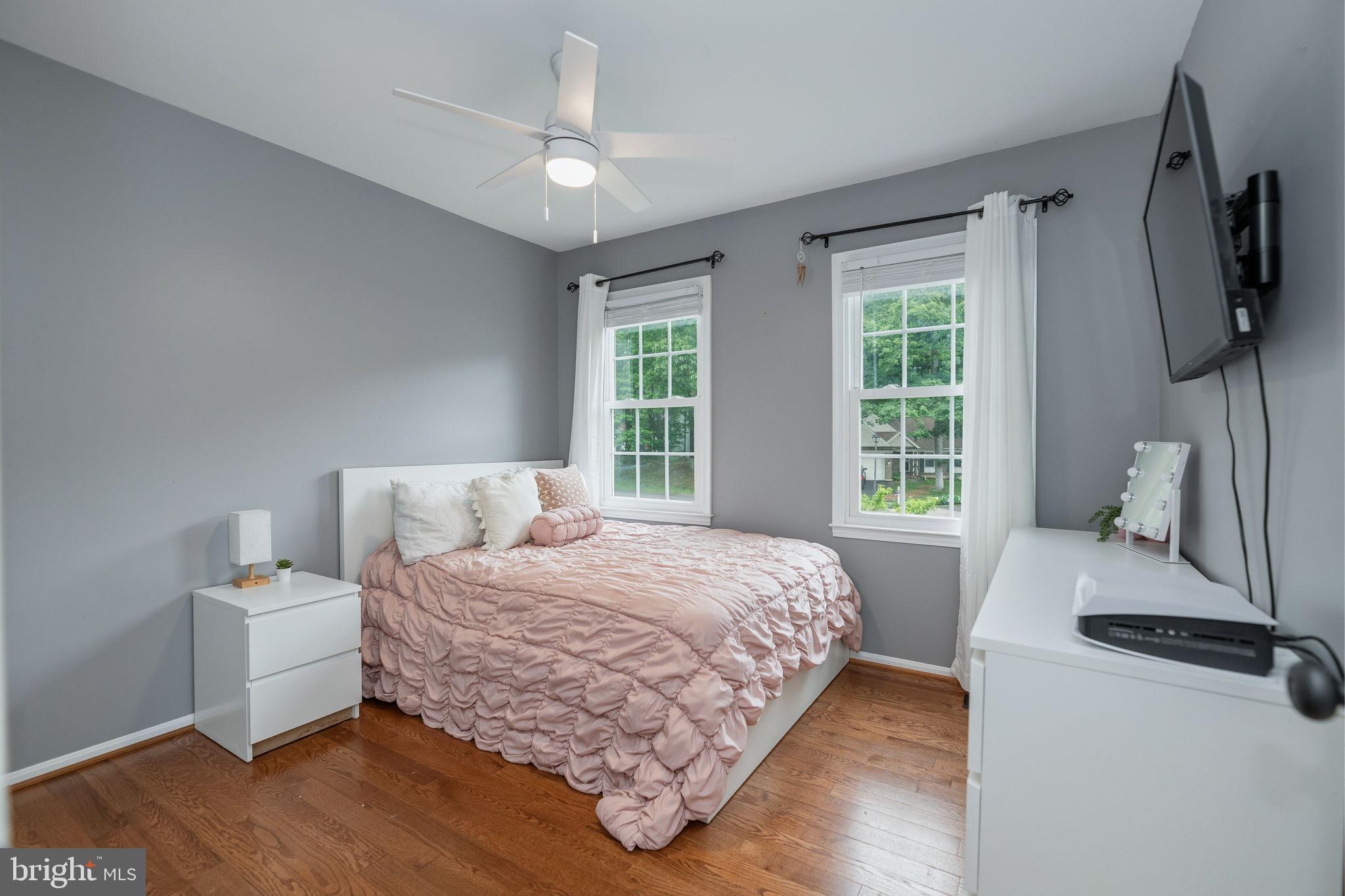 7603 Modisto Lane Springfield, VA 22153 - Photo 27 of 57 a bedroom with a bed wooden floor and a flat tv screen on dresser