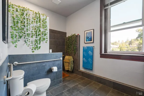 a kitchen with stainless steel appliances a sink a dining table and chairs with wooden floor