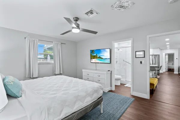 a spacious bedroom with a bed and a flat screen tv