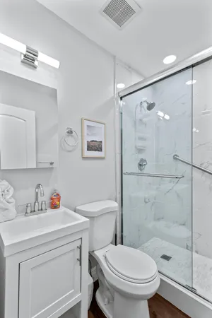 a bathroom with a sink toilet vanity and shower