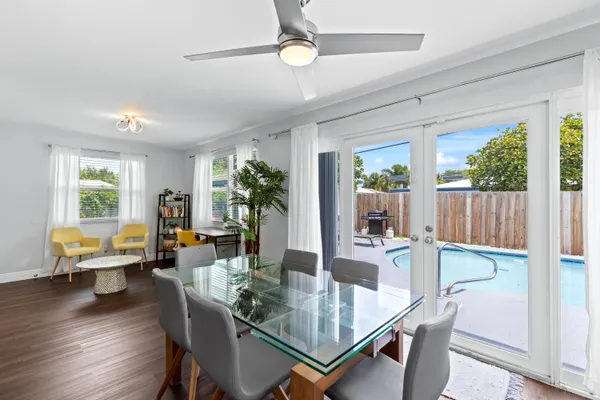 a dining room with furniture a chandelier and wooden floor