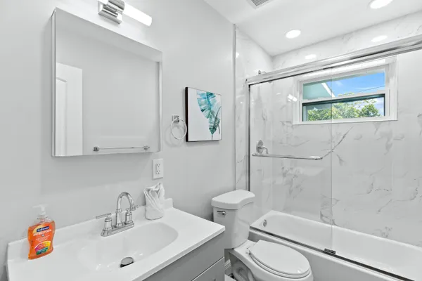 a bathroom with a sink a toilet and shower