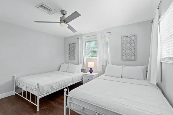 a bedroom with two beds and window