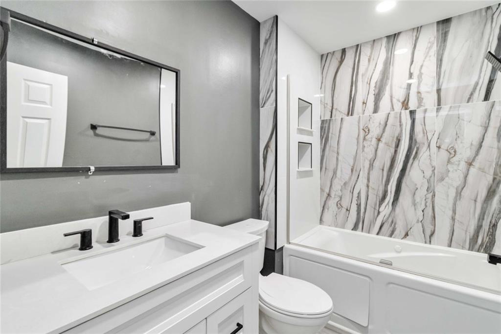 292 Natchez Circle Winder, GA 30680 - Photo 13 of 29 a bathroom with a sink a toilet and a mirror