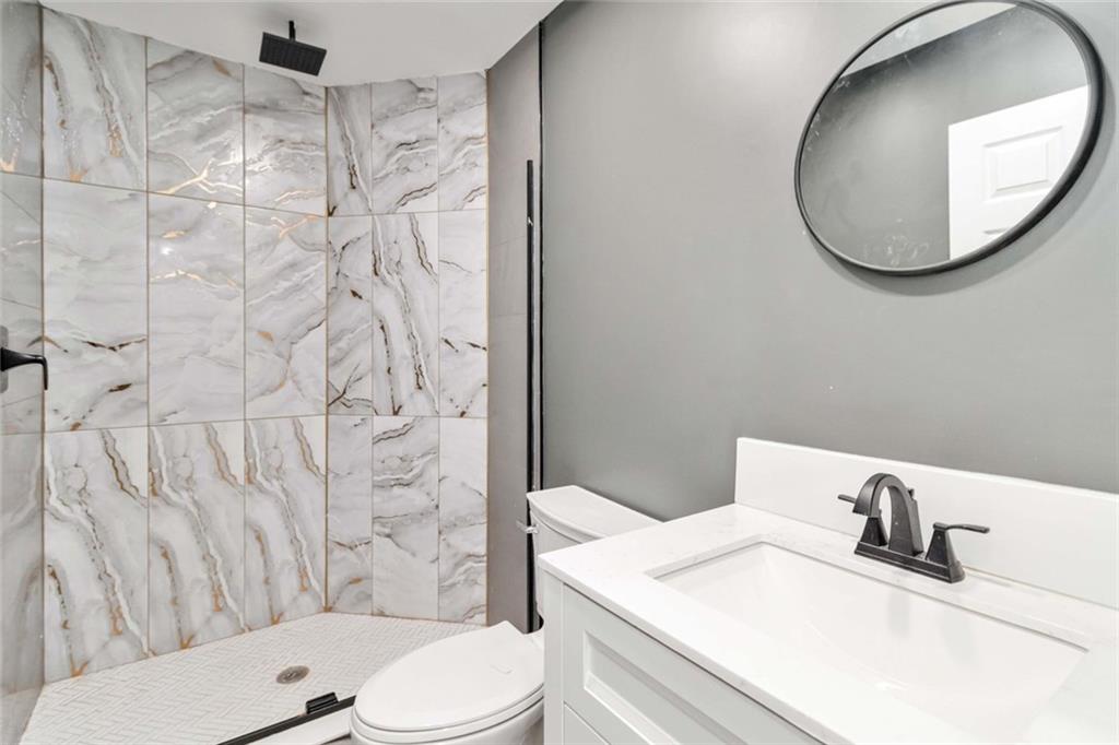 292 Natchez Circle Winder, GA 30680 - Photo 4 of 29 a bathroom with a granite countertop toilet sink and mirror